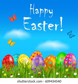Easter greeting card with colorful eggs. Nature background with butterfly flying above grass and flowers.