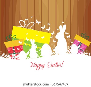 Easter greeting card with rabbit, gift and lights on the wooden background