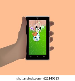 Easter. Hold in your hand a smart phone. Illustration for your design. Eared rabbit-egg coloring in circles to keep a large candy-shaped candy in the shape of a heart