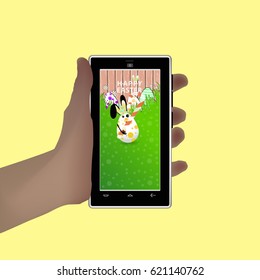 Easter. Hold in your hand a smartphone. Illustration for your design. Eared rabbit-egg hold caramel-shaped stick striped