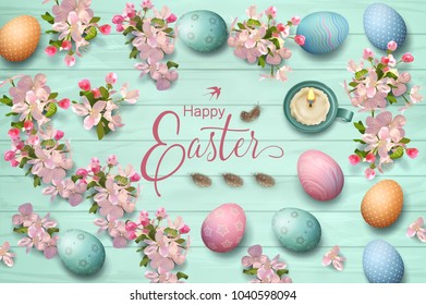 Easter holiday background with painted eggs, spring flowers, feathers and candle on wooden background. Top view composition