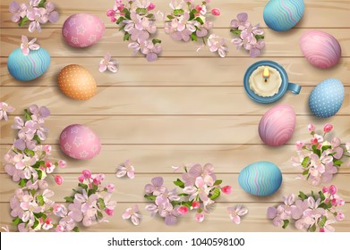 Easter holiday background with painted eggs, spring flowers and candle on wooden background. Top view composition