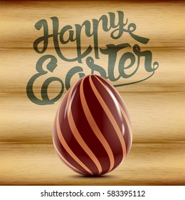Easter holiday postcard with decorated chocolate egg isolated on wood background, vector realistic illustration with greeting lettering