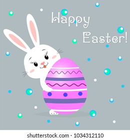 Easter rabbit peeks because of a purple decorative egg with a pattern. Congratulations on Easter.