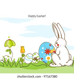 Easter scene, white bunny and painted eggs in the grass