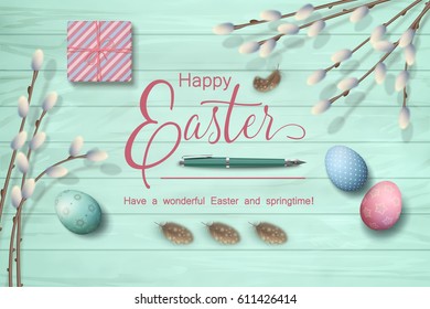 Easter top view wooden background with Happy Easter lettering, pen, gift, eggs, pussy willow branches, feathers.