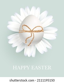 Easter white egg on a daisy, tied with twine