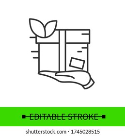 Eco friendly delivery service icon. Outline label with hand holding product in green recyclable package. Environment friendly transportation concept. Linear vector illustration.Editable stroke
