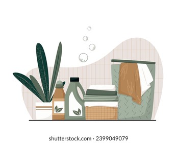 Eco friendly organic natural laundry detergents, fabric softener, soap gel bottle with branch of green leaves, basket with clean towels and laundry basket in bathroom. Eco hygiene products.