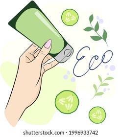 Eco hand cream. A woman's hand holds a tube of cream. Hand cream. Cucumber slices and sprigs of herbs.