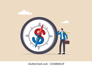 Economic direction or investment trend, financial indicator, inflation or interest rate direction, recession or growth concept, businessman investor looking at compass with dollar sign direction.