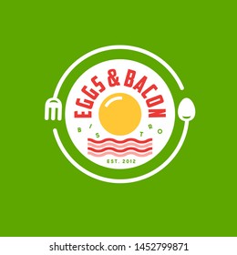  Eggs and Bacon logo. Cafe or restaurant emblem. Fork, spoon and fried eggs with bacon in the green background. Street food icon.