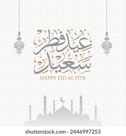 Eid Fitr Saeed greeting card in arabic calligraphy with silhouette mosque and lantern on arabesque pattern background , translation : "happy eid al fitr"