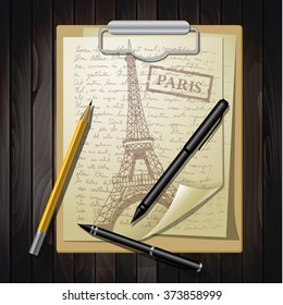 eiffel tower on white paper with pens and pancil on top of  wooden table