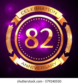 Eighty two years anniversary celebration with golden ring and ribbon on purple background.