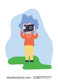 An elder woman - photographer taking pictures with camera in travelling. Aged tourist with gray hair