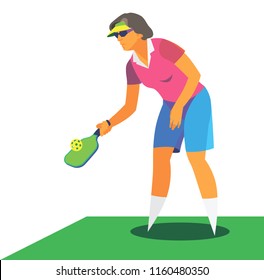 An elderly active woman in a red shirt is a player in the pickleball on the tennis court