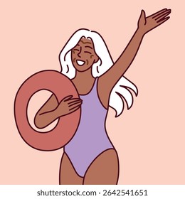 Elderly Black woman in swimsuit with inflatable ring smiles and waves, enjoying beach vacation and active golden years.