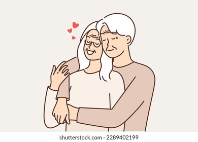 Elderly couple in love from gray-haired man and woman hugging and remembering youth or first date. Tender elderly couple flirting and enjoying relationship and long happy marriage 