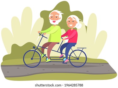 Elderly couple riding twin or tandem bicycle on road in park or lawn. Old woman and man are spending time actively. People in relationship together in nature. Grandparents riding double bike