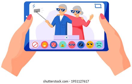 Elderly couple standing with monopod against background of window and making photo together on phone