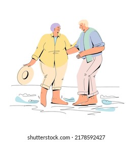 An elderly couple walks by the sea.