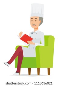 An elderly male chef wearing a cook coat is reading on a sofa