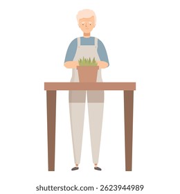 Elderly man in gardening overalls carefully repotting a plant on a table, enjoying his hobby