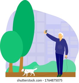 an elderly man takes pictures of himself on the phone, I’m Grandfather takes a selfie, a gray-haired man walks in a city park with a dog and holds a smartphone in his hands,elderly people use digital 