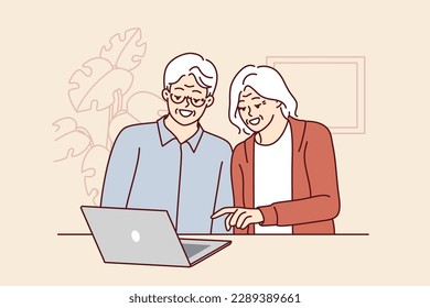 Elderly men and women are sitting at table with laptop learning how to handle modern technology and computer literacy. Elderly couple make video call to children using laptop with internet