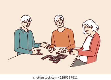 Elderly people play dominoes undergoing rehab at nursing home or having sunday get-together with friends. Men and women are sitting at table enjoying game of dominoes with former colleagues 