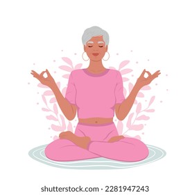 Elderly woman with closed eyes meditating in yoga lotus posture. Stress Awareness Month. The concept of zen and harmony. Mental Health Awareness Month