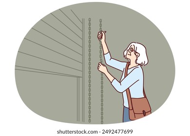 Elderly woman closes shop to store after end of working hours and departure of customers from store or cafe. Grey-haired female small business owner ends working day by closing doors to trading floor
