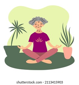 Una anciana medita junto a las plantas de la casa. Yoga en casa. 