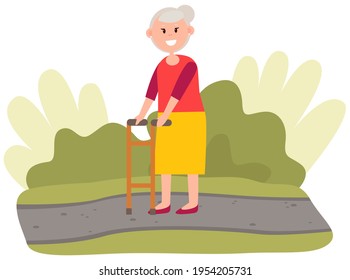 Elderly woman moving with help of front-wheeled walker. Disabled lady spending time in park