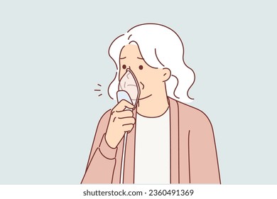 Elderly woman with oxygen mask near face, stands using medical equipment for artificial ventilation of lungs. Old female suffering from bronchial disease causing affected lungs and breathing problems