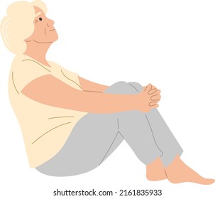 An elderly woman is sitting on the floor and looking up.