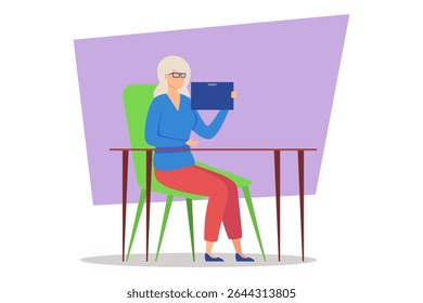 Elderly woman with white hair and glasses sitting at chair by wooden table, engaged with tablet device. Woman focused and attentive to what she examining