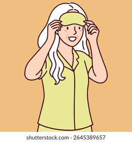 Mulher idosa com cabelo branco usa pijamas e coloca máscara de dormir preparando-se para o sono tranquilo e bem-estar noturno rotina