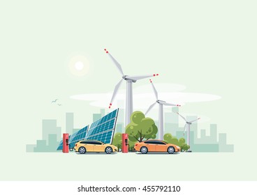 Electric cars charging at the charger station in front of the solar panels and wind turbines. City skyline in the background.