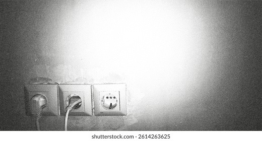 Electrical outlet with cables attached against a textured wall in a well-lit room