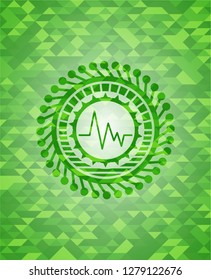 electrocardiogram icon inside green emblem with mosaic background