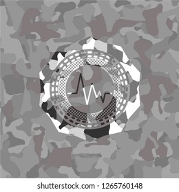 electrocardiogram icon inside grey camouflage emblem