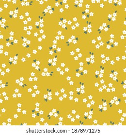 Elegant floral pattern of small flowers . The style of freedom. Small white flowers . Yellow background. Floral seamless background for fashion prints. Printing color in a flower. Seamless vector text