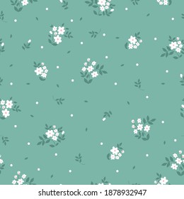 Elegant floral pattern in small white flowers. The style of freedom. Green background. Floral seamless background for fashion prints. Printing color in a flower. Seamless vector texture. Spring bouque