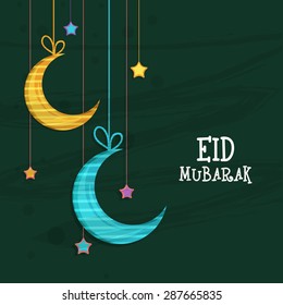 Elegant greeting card design decorated with shiny hanging crescent moons and stars on green background for Muslim community festival, Eid Mubarak celebration.