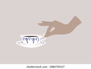 Elegant hand holding a porcelain teacup, breakfast time