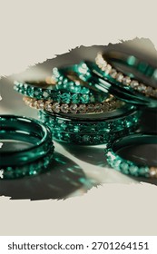 Elegantes anillos metálicos esmeralda superpuestos con iluminación reflectante de gradiente de lujo.