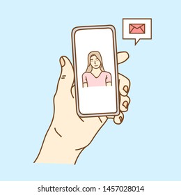Email app on smartphone screen. You receive a message, New message is received. Man's Hand holding a smartphone