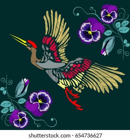 Embroidered crane on a background of beautiful flowers on a black background. Vector illustration.